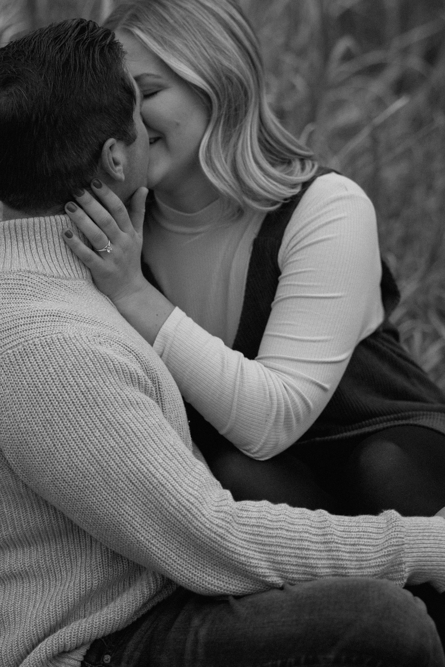 Two people stand together on a golden grassy hillside during an overcast autumn day.