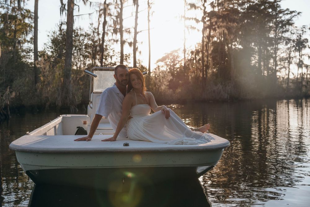 Couple embracing in a small boat during a romantic engagement session on the Pasquotank River in Elizabeth City, North Carolina.