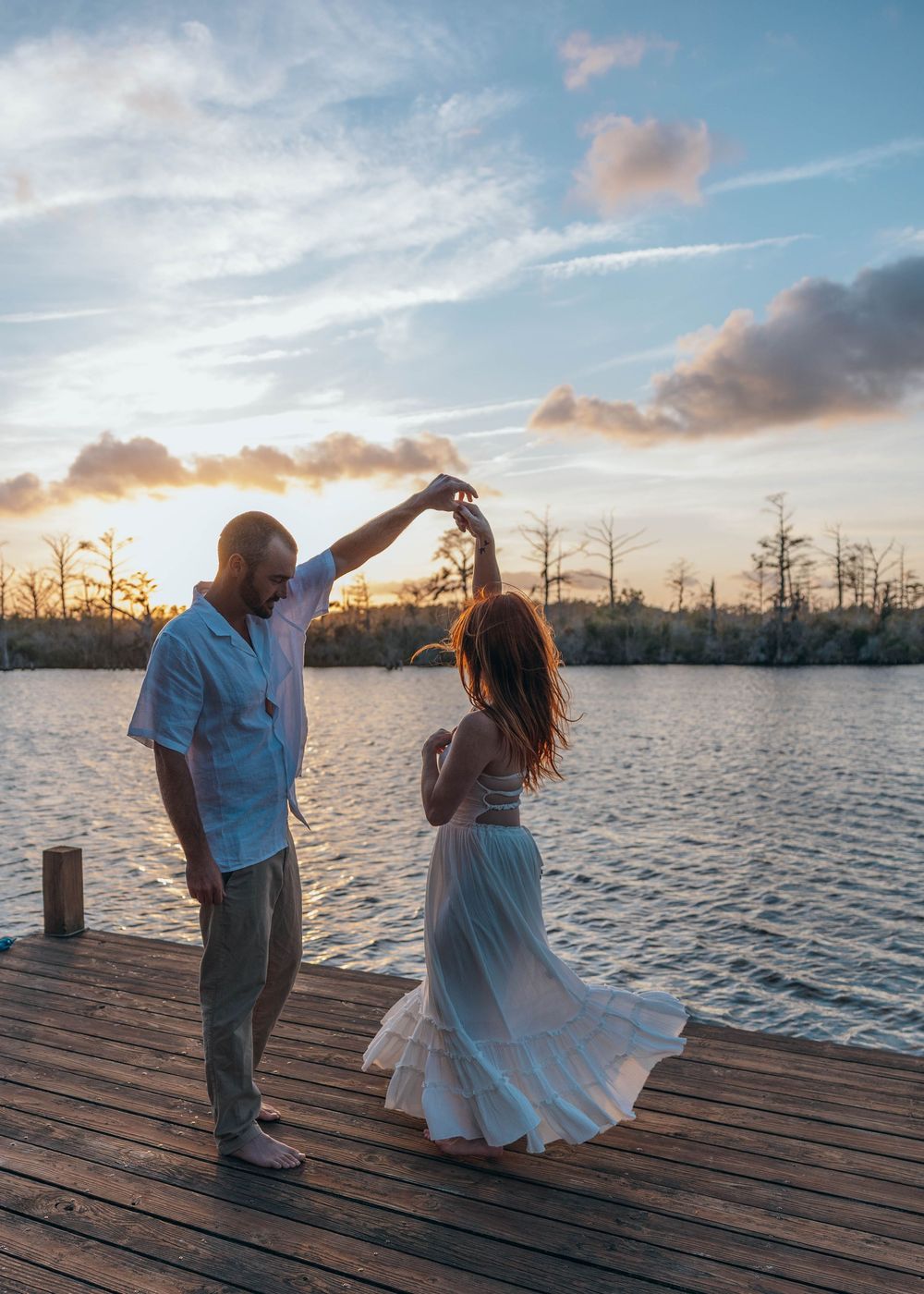 Engaged couple dancing together for sunset engagement session on the Pasquotank River in Elizabeth City, North Carolina.
