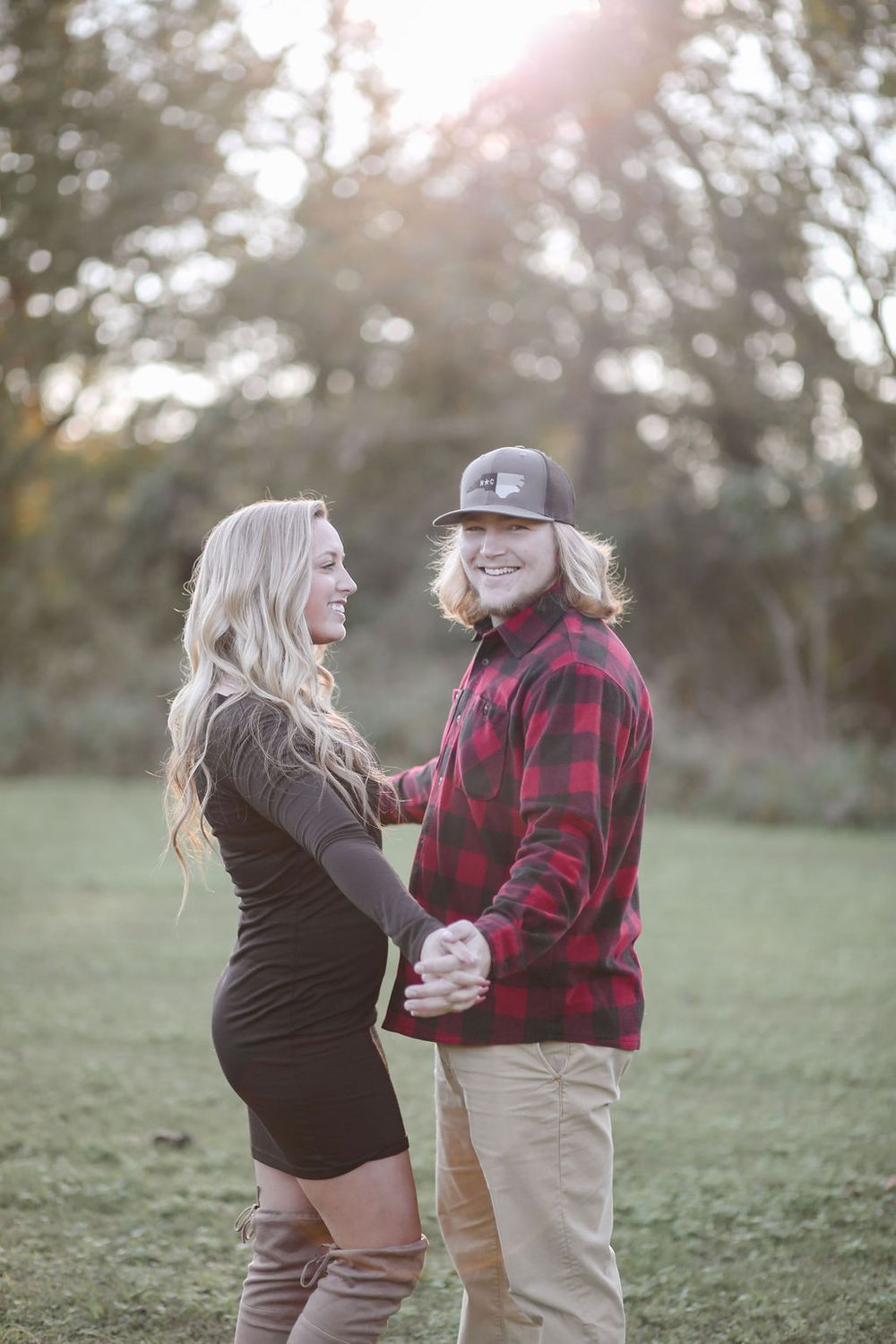 Romantic engagement session of a joyful couple outdoors with natural light in North Carolina.
