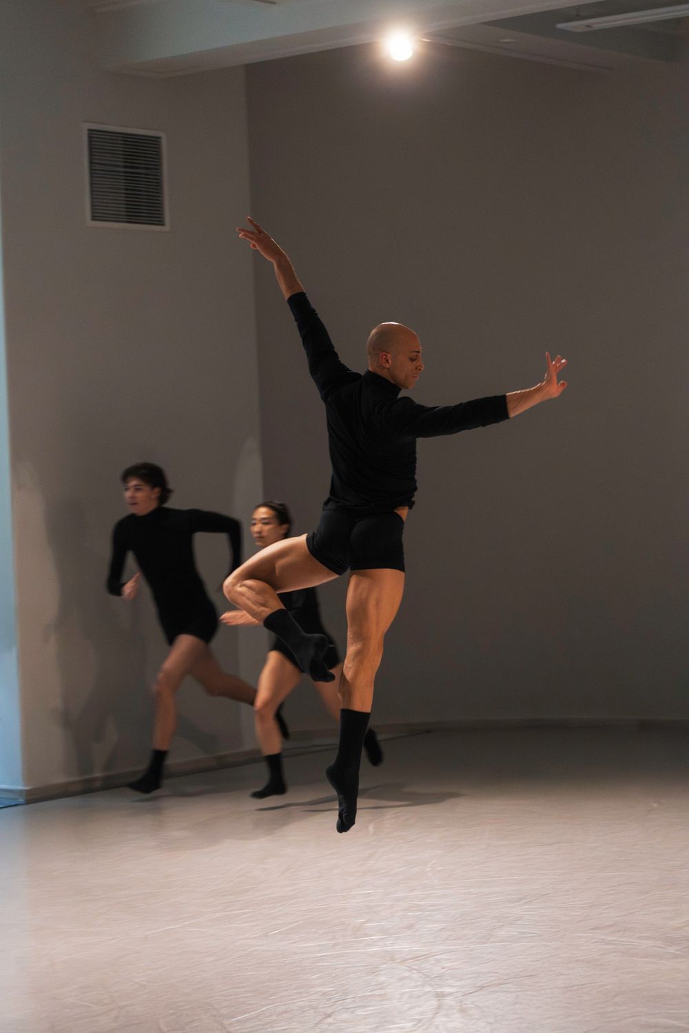 Modern dancer in black attire performs a dynamic floor sequence across five progressive movement poses.
