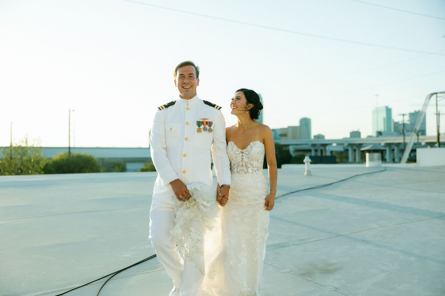 Couple in white uniforms walking on rooftop.