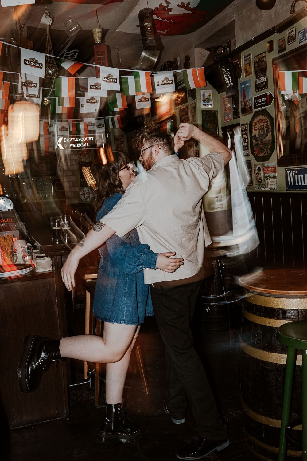 Sequence of a dancing couple at a dimly lit bar spinning and performing dance moves together.