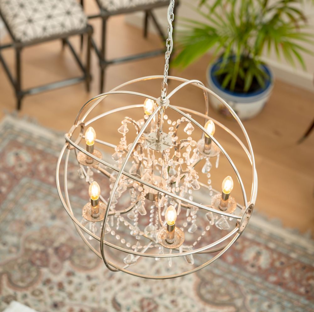 Crystal orb chandelier with concentric metal rings illuminating a modern living space.