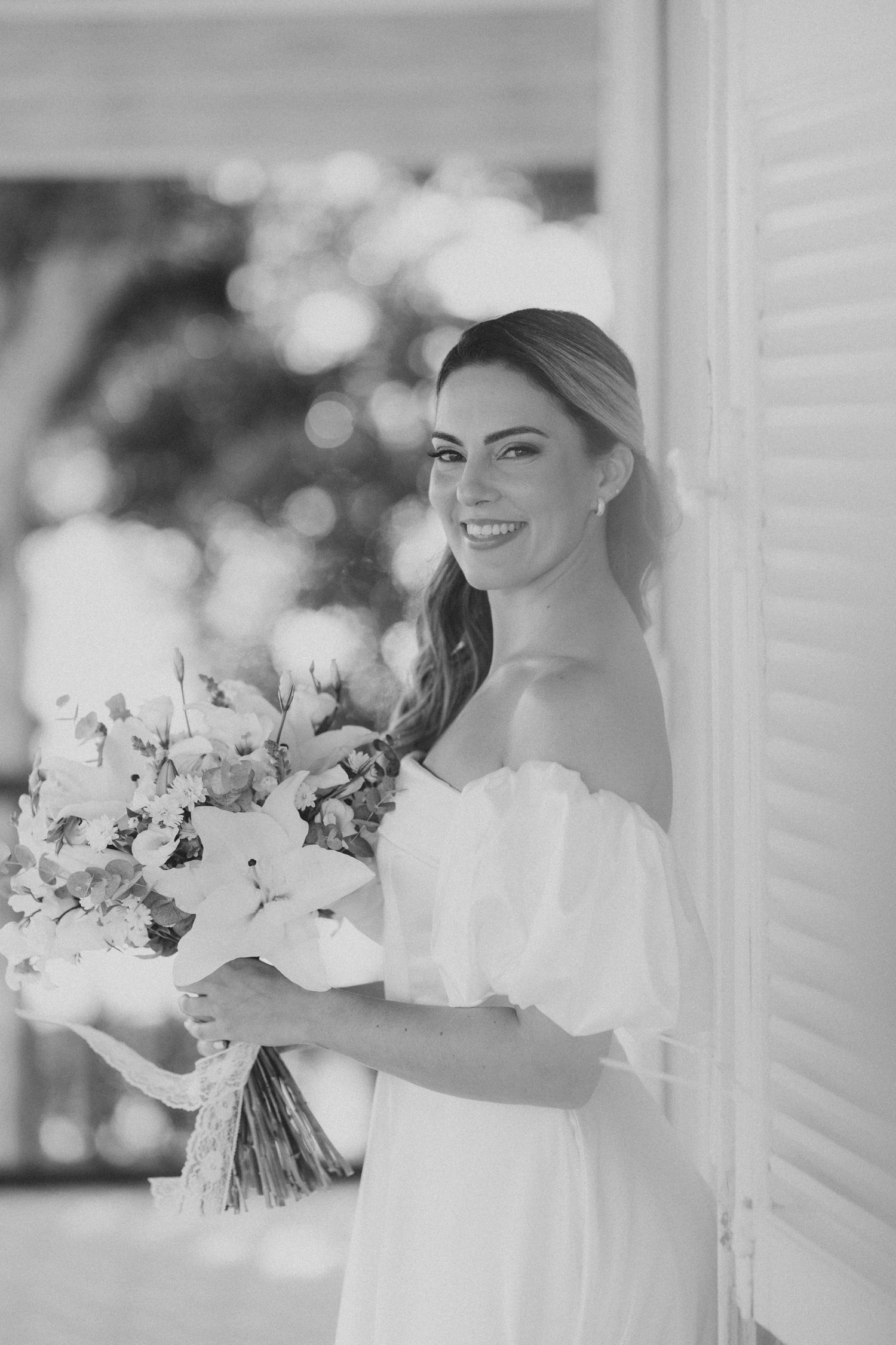 Black and white photo of people with flowers preparing for a wedding celebration.