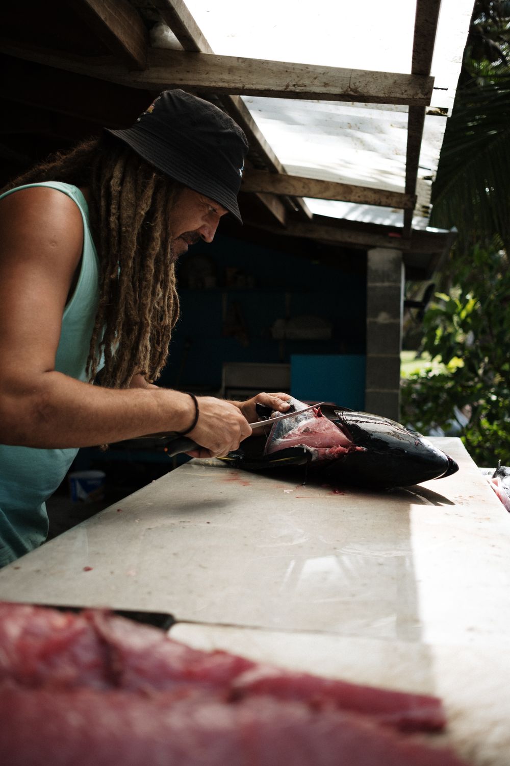 A knife peels away layers from a palm tree trunk while creating ribbons of natural material.