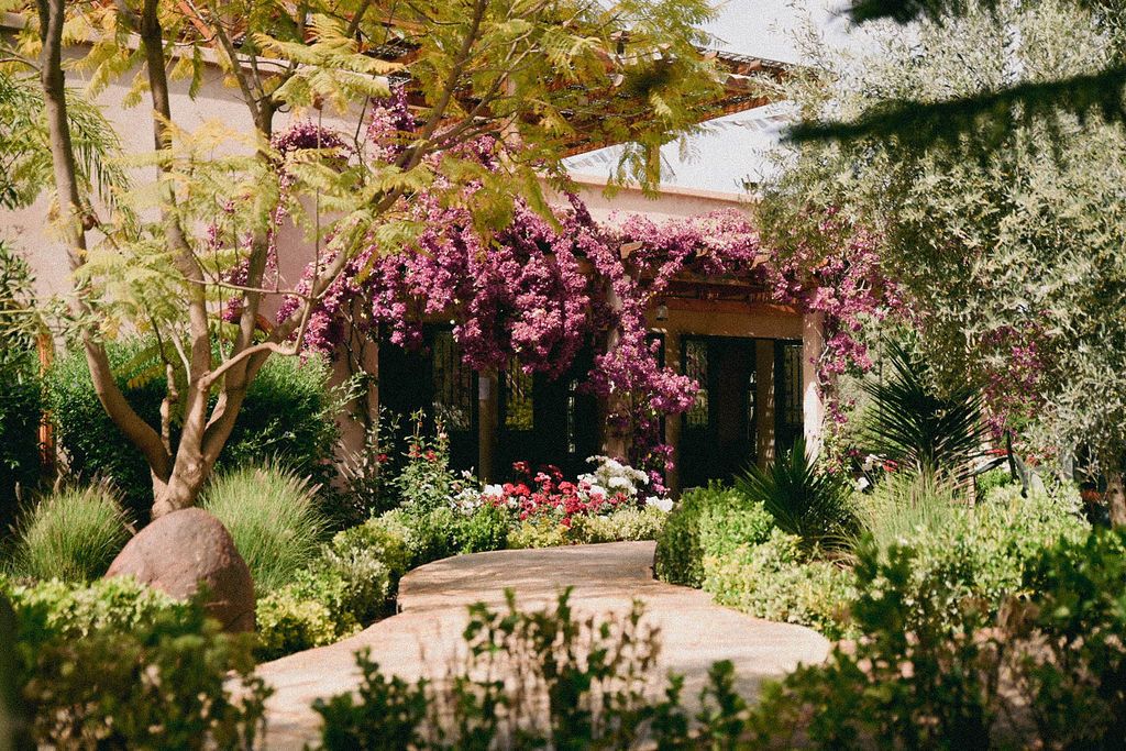 Allée fleurie bordée de bougainvilliers, créant une atmosphère apaisante propice aux retraites spirituelles.