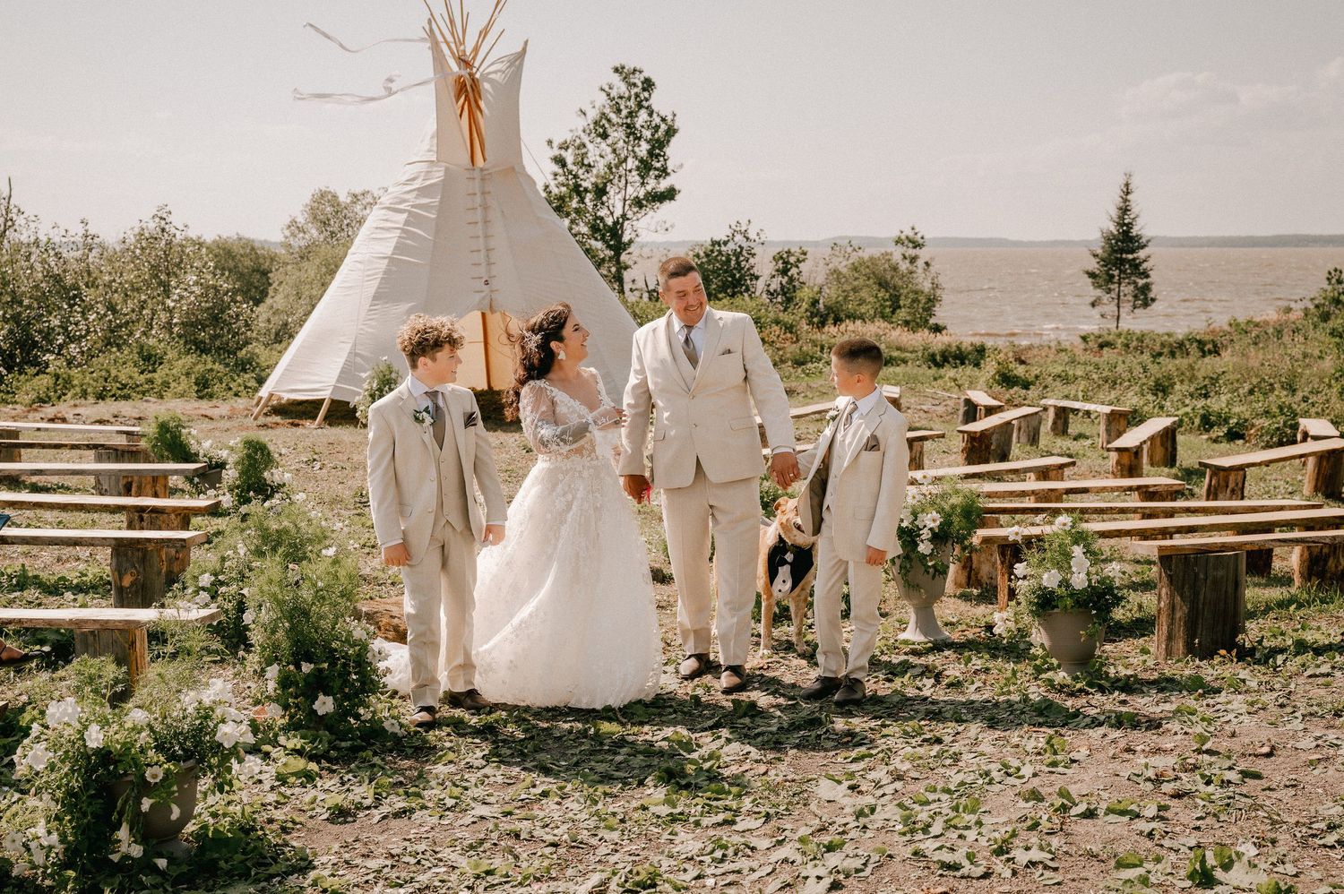 Couple poses back-to-back against lakeside backdrop during wedding photoshoot.