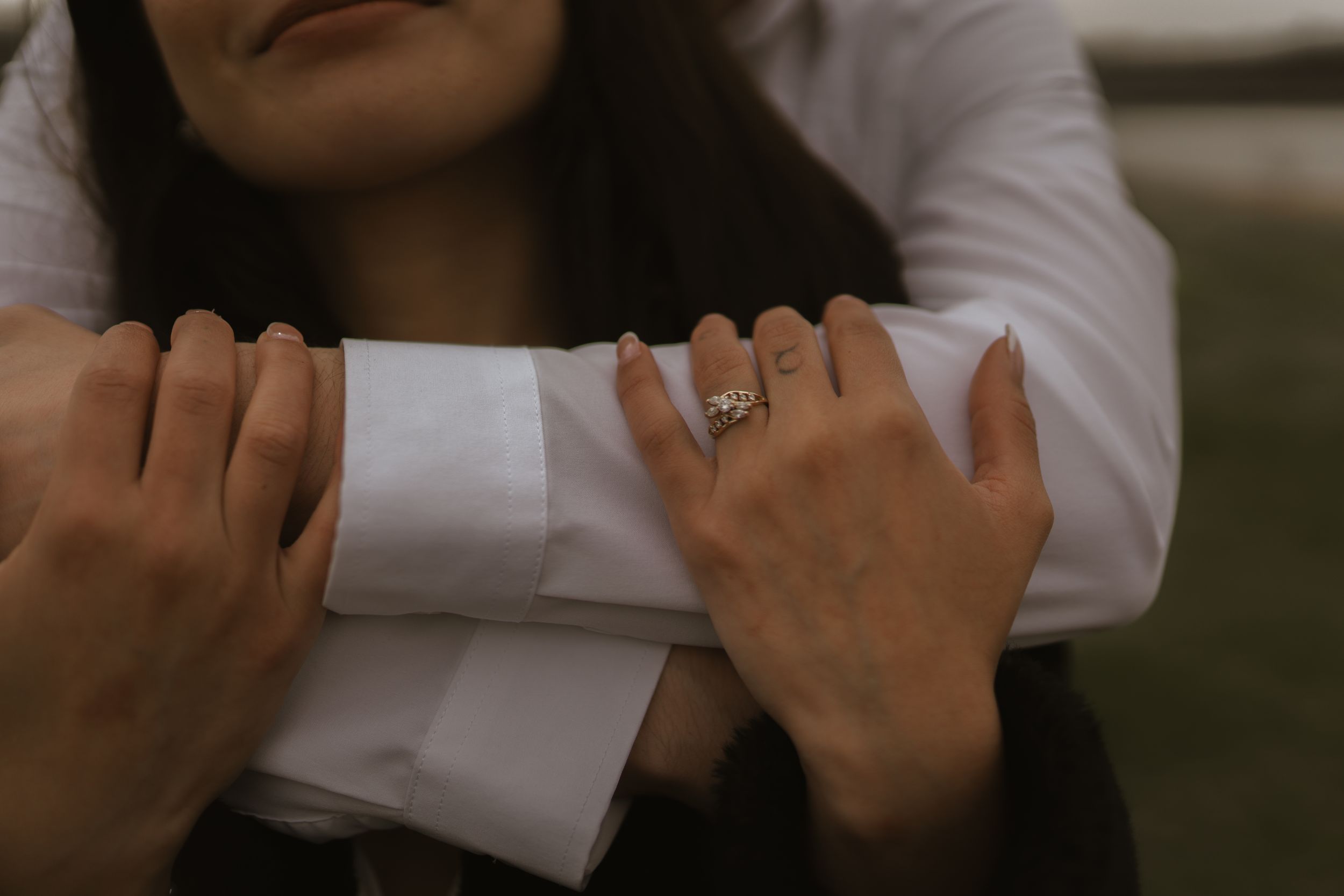 Close-up shot showing hands and arms embracing in an intimate moment.