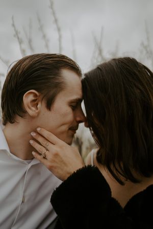 Close-up romantic moment captured in moody black and white tones.