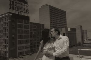 Urban rooftop scene with brick buildings and a vintage sign visible in the background.