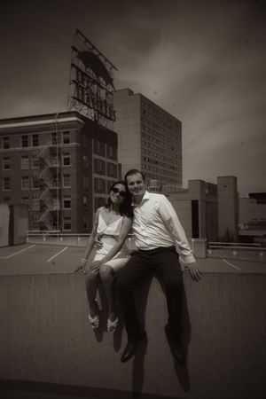 Vintage style photo of couple on urban rooftop with moody sky.