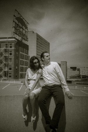 A sequence of black and white photos showing two people jumping over a wall in an urban setting.