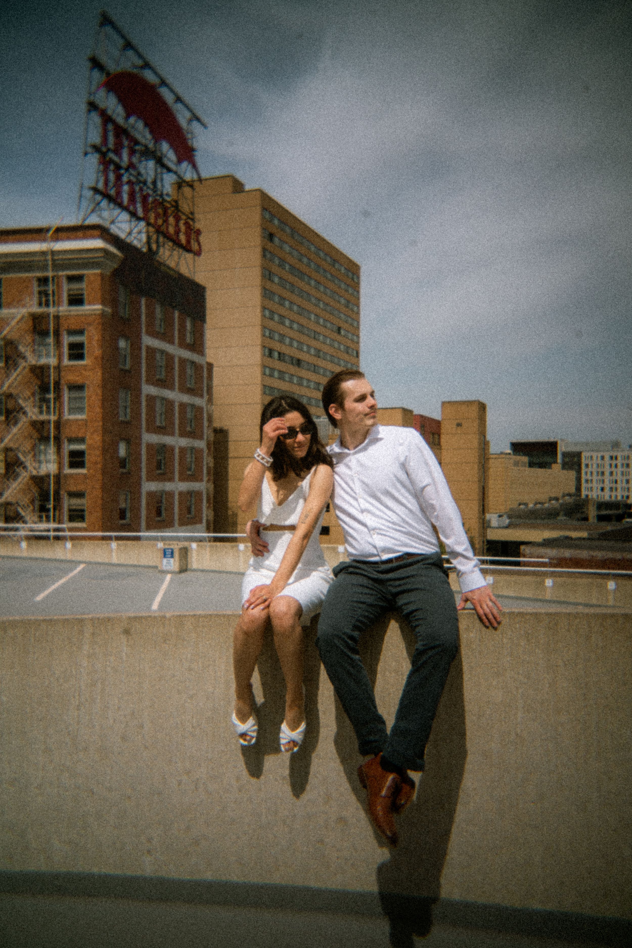 A series of photos capturing people leaping over a concrete wall against a cloudy urban backdrop.