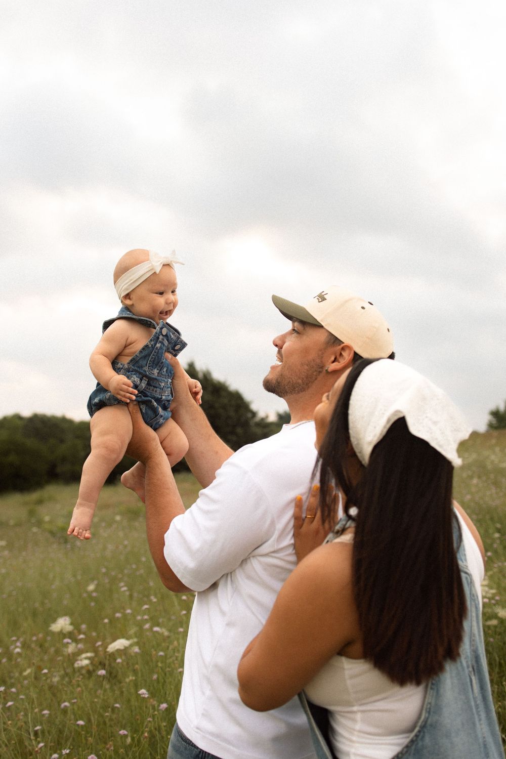 A family spending time together in a wildflower meadow on a cloudy summer day.
