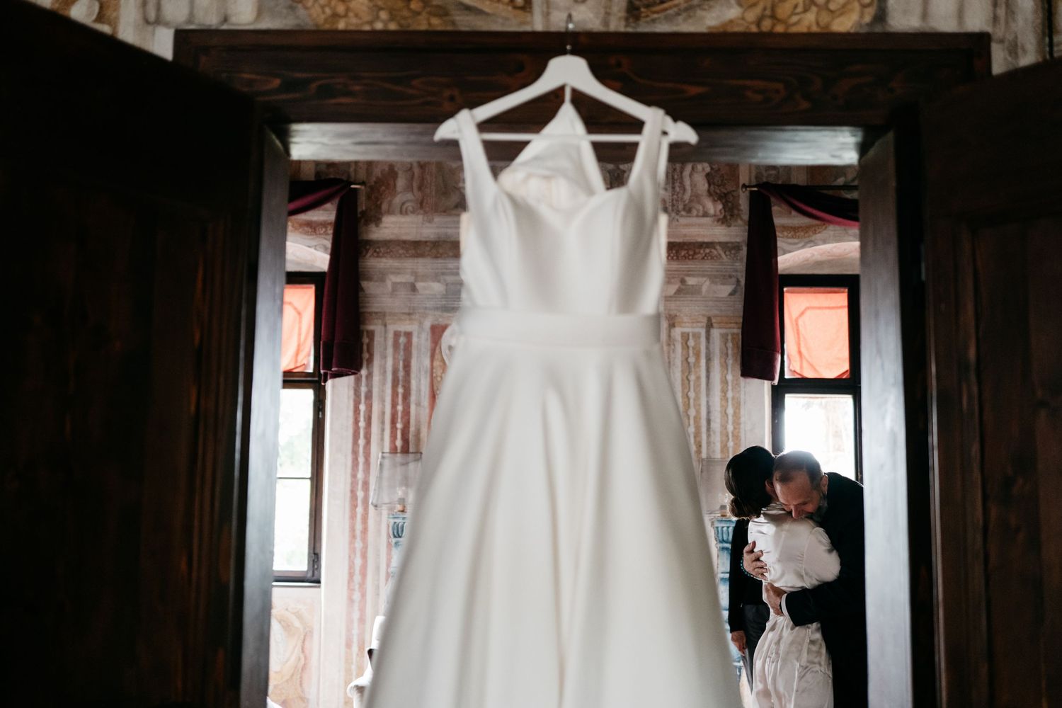 Wedding ceremony at a rustic stone chapel overlooking scenic mountain views with guests gathered outdoors.