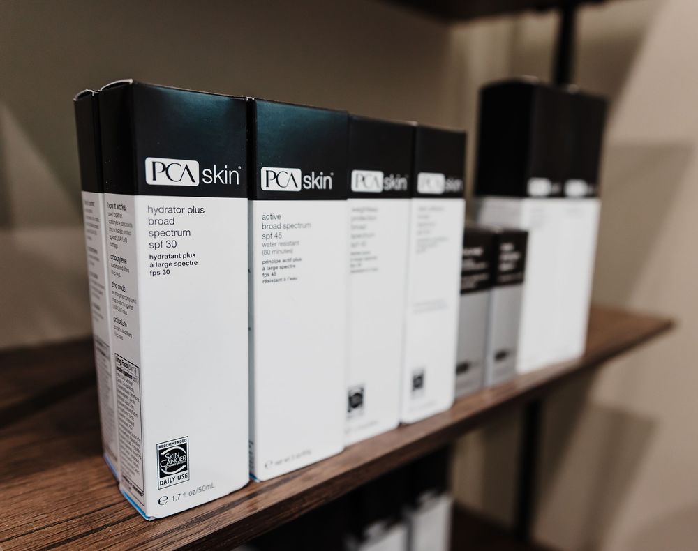 A row of white product boxes displayed on a dark wooden shelf with DCM skin labels.