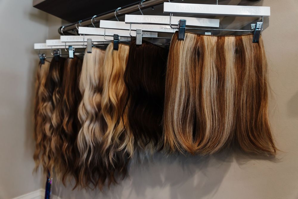 Rows of hair extensions in varying shades of blonde and brown hang neatly on wall-mounted display racks.