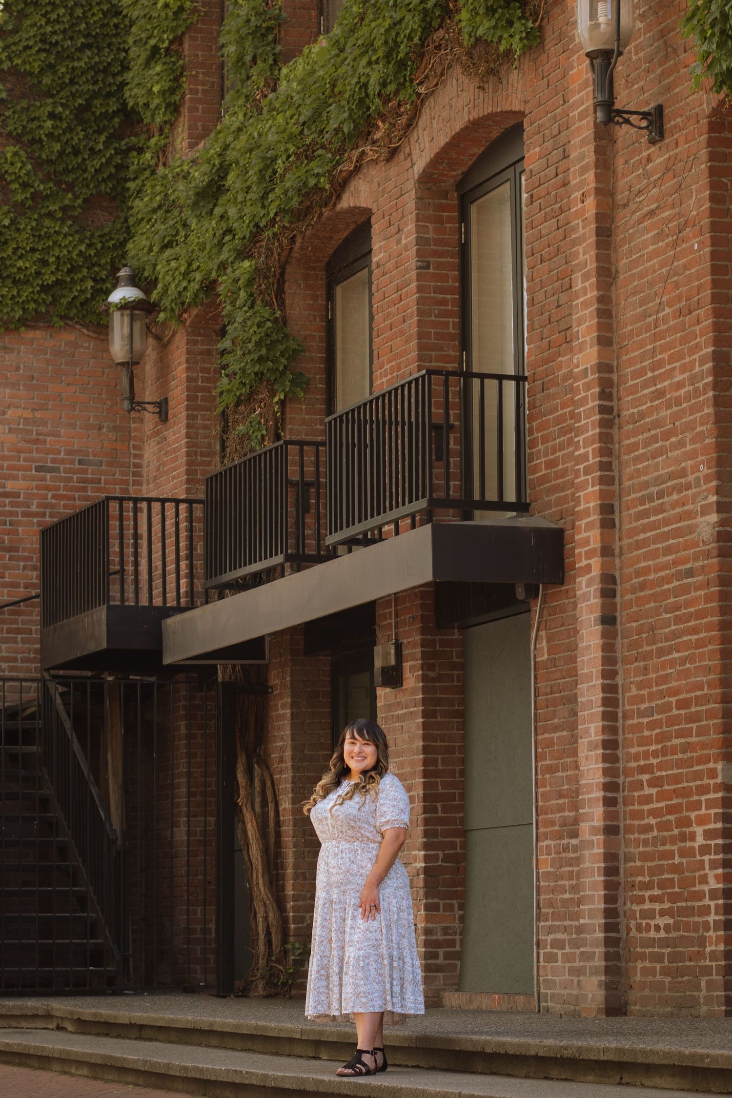 Cristina Sosa Life Path Coaching posed in front of brick building with ivy in Downtown Spokane, WA.