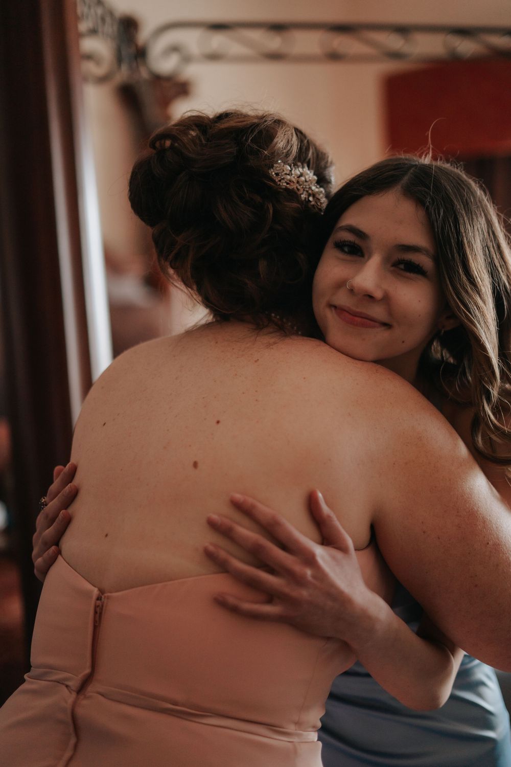 A warm embrace captured in soft lighting between two people in formal wear.