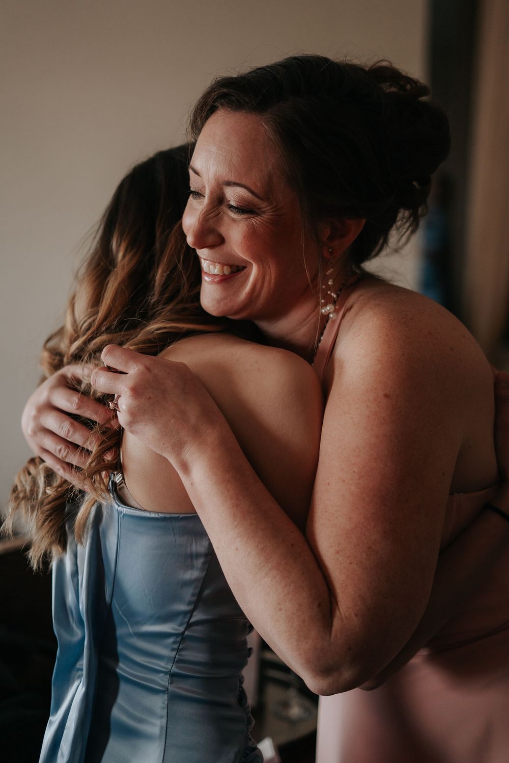 An emotional embrace between two people wearing formal attire.