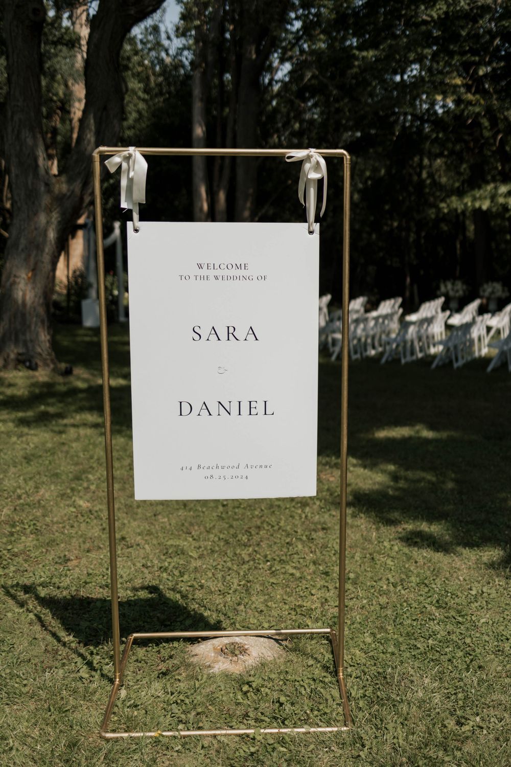 Elegant gold stand wedding welcome sign for Sara and Daniel outdoor ceremony.