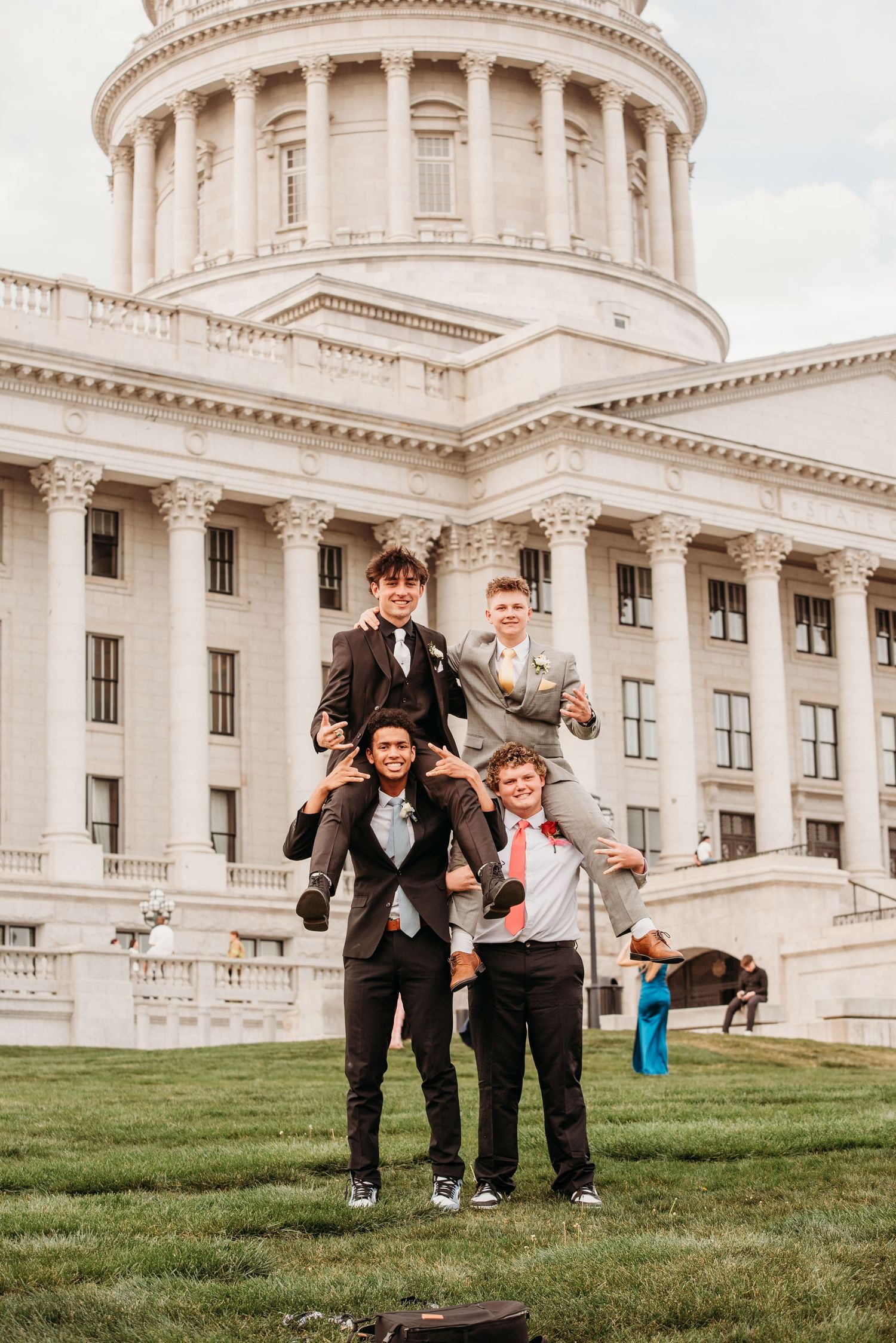 A group of people posing together on the lawn in front of the Utah State Capitol building in Salt Lake City.