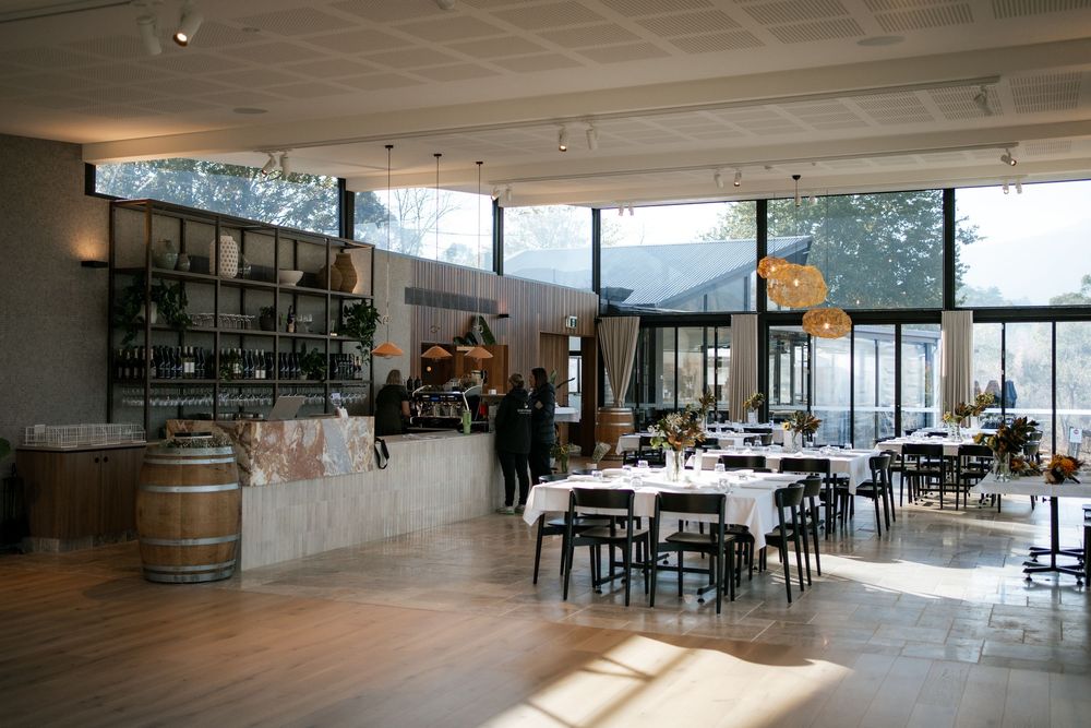 Modern reception venue interior with large windows and barrel decor.