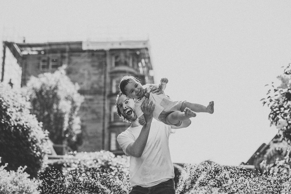 Black and white photo of joyful outdoor play with water on a bright summer day.