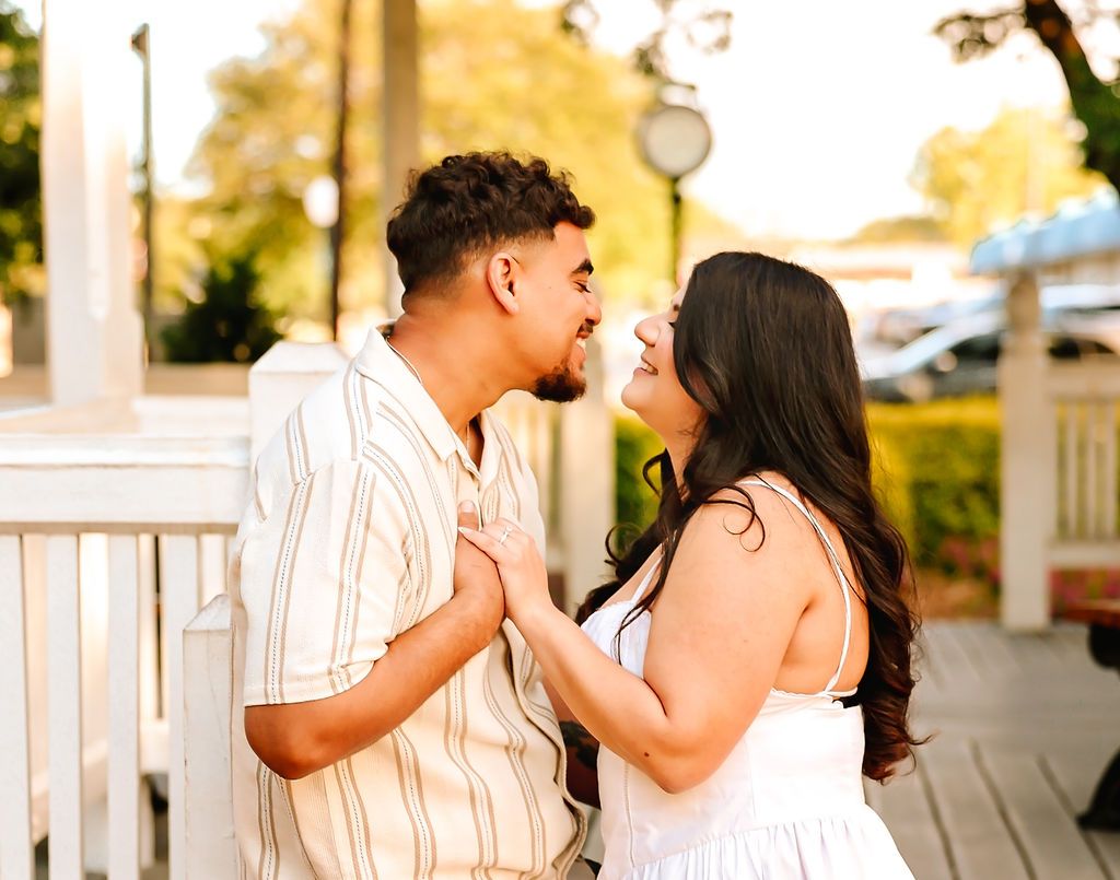 Couple looking at one another and holding hands during proposal and engagement session