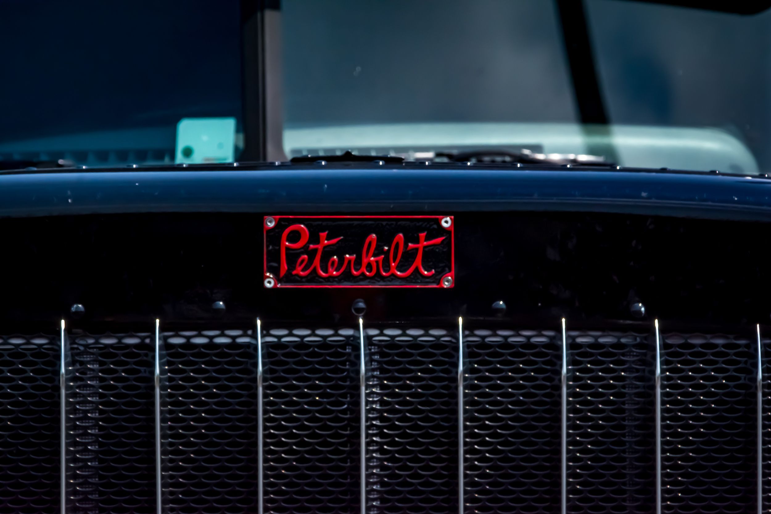 Peterbilt truck nameplate glowing red on chrome grille close up detail Joplin, Missouri
