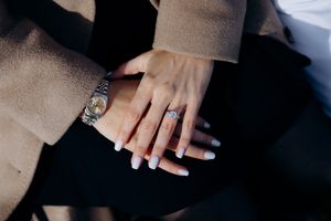 Close-up of two hands showing an engagement ring with diamond and a Rolex watch, symbolizing love and luxury in the Cotswolds.