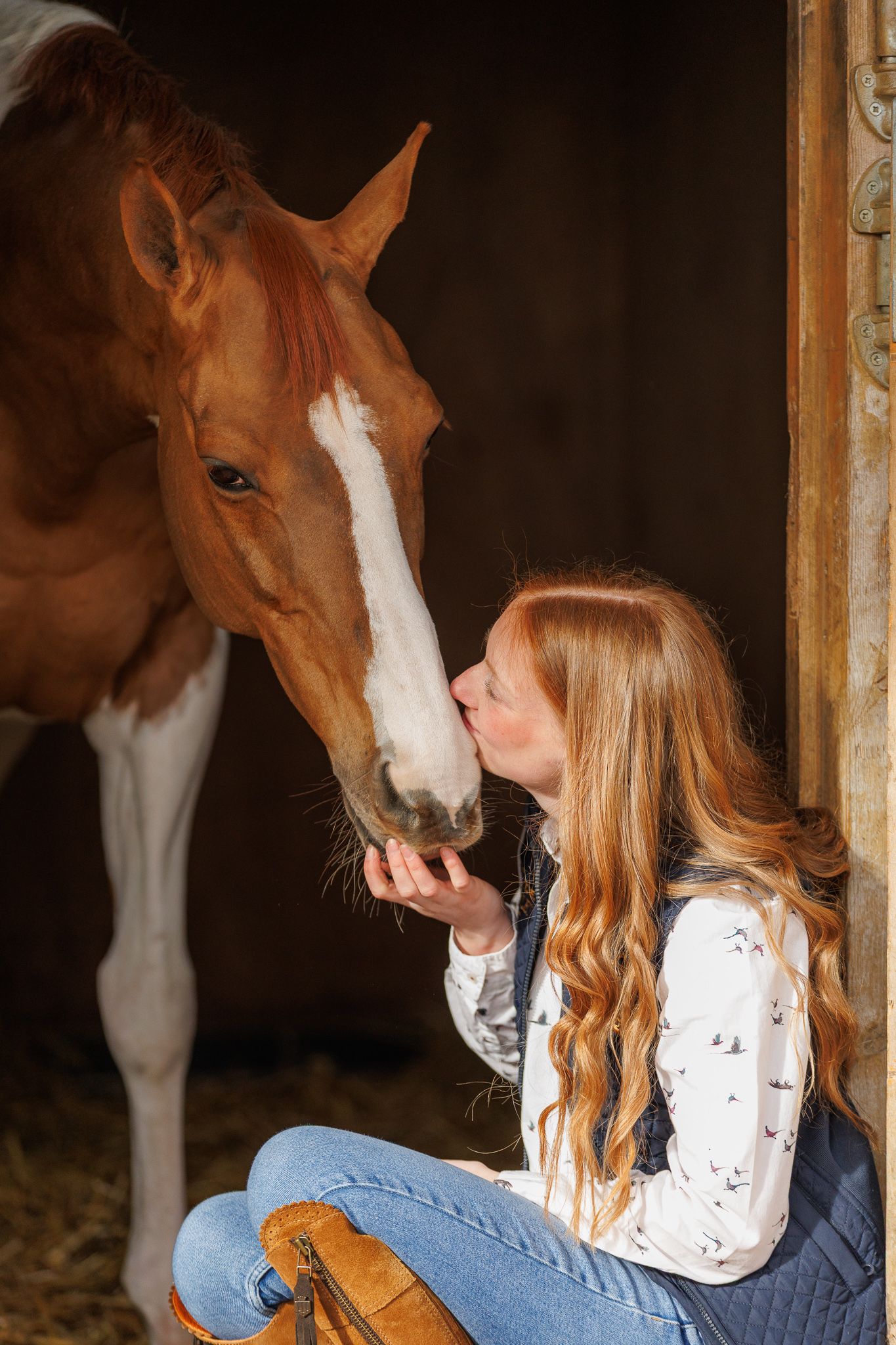 A series of photos showing a person with red hair interacting with a dark horse in a soft-focus outdoor setting.