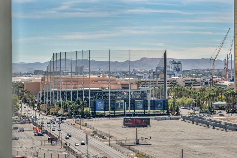 Aerial view of Allegiant Stadium and surrounding Las Vegas area with mountains in the distance.