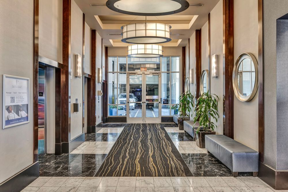 Luxurious hotel lobby with marble floors, high ceilings, and elegant pendant lighting.