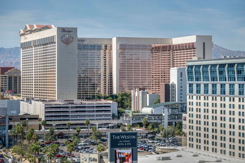 Aerial view of Las Vegas Strip featuring the Westgate and Westin hotels with mountain backdrop.