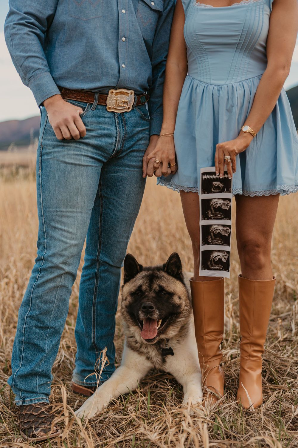 Cowboy holds wife while showing off ultrasound photos with their dog in the mountains of Red Lodge, Montana captured by Montana Photographer