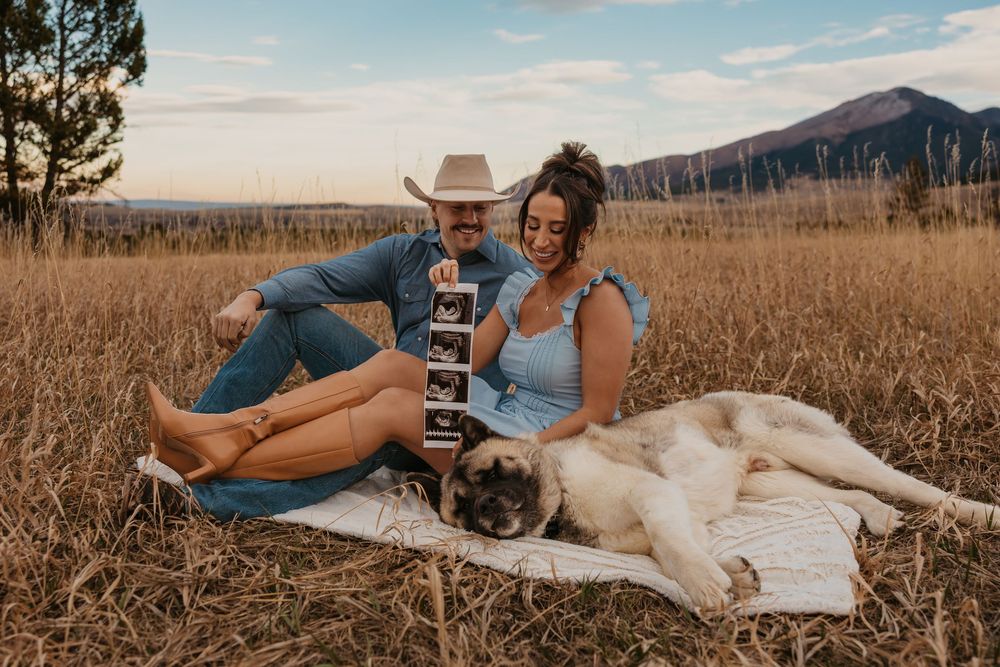 Couple cuddling shows off ultrasound photos with their dog in the mountains of Red Lodge, Montana captured by Montana Photographer