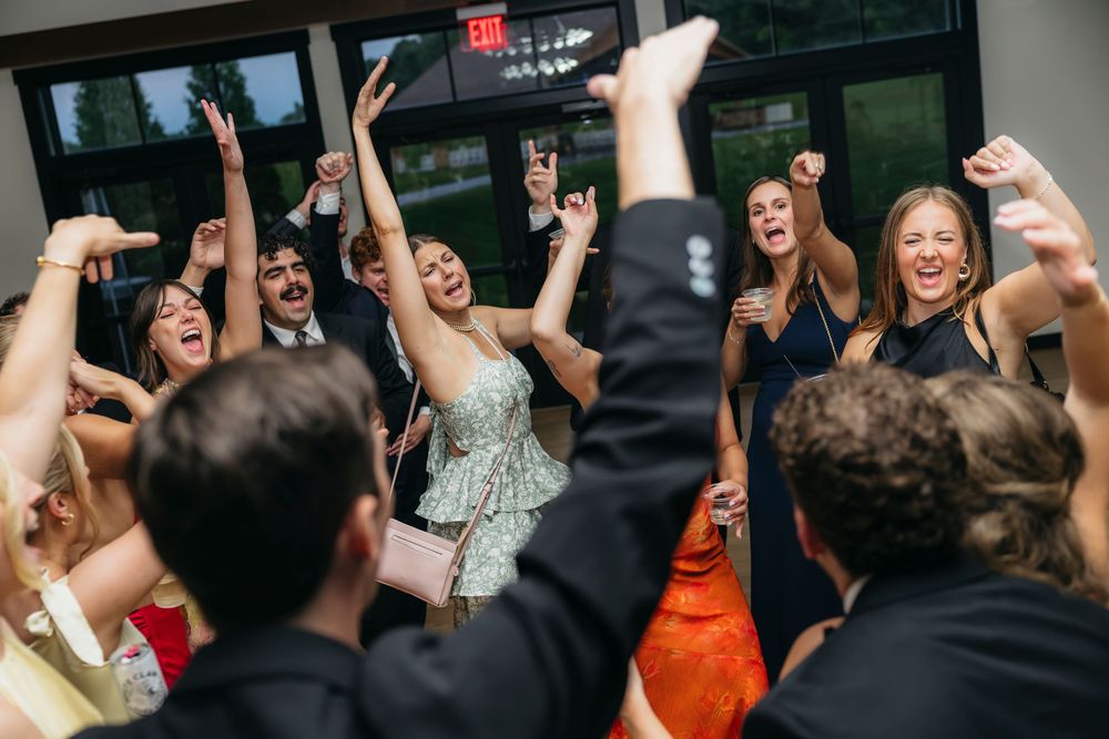 Guests celebrate joyfully on the dance floor at a wedding reception captured by candid photographer in Wisconsin