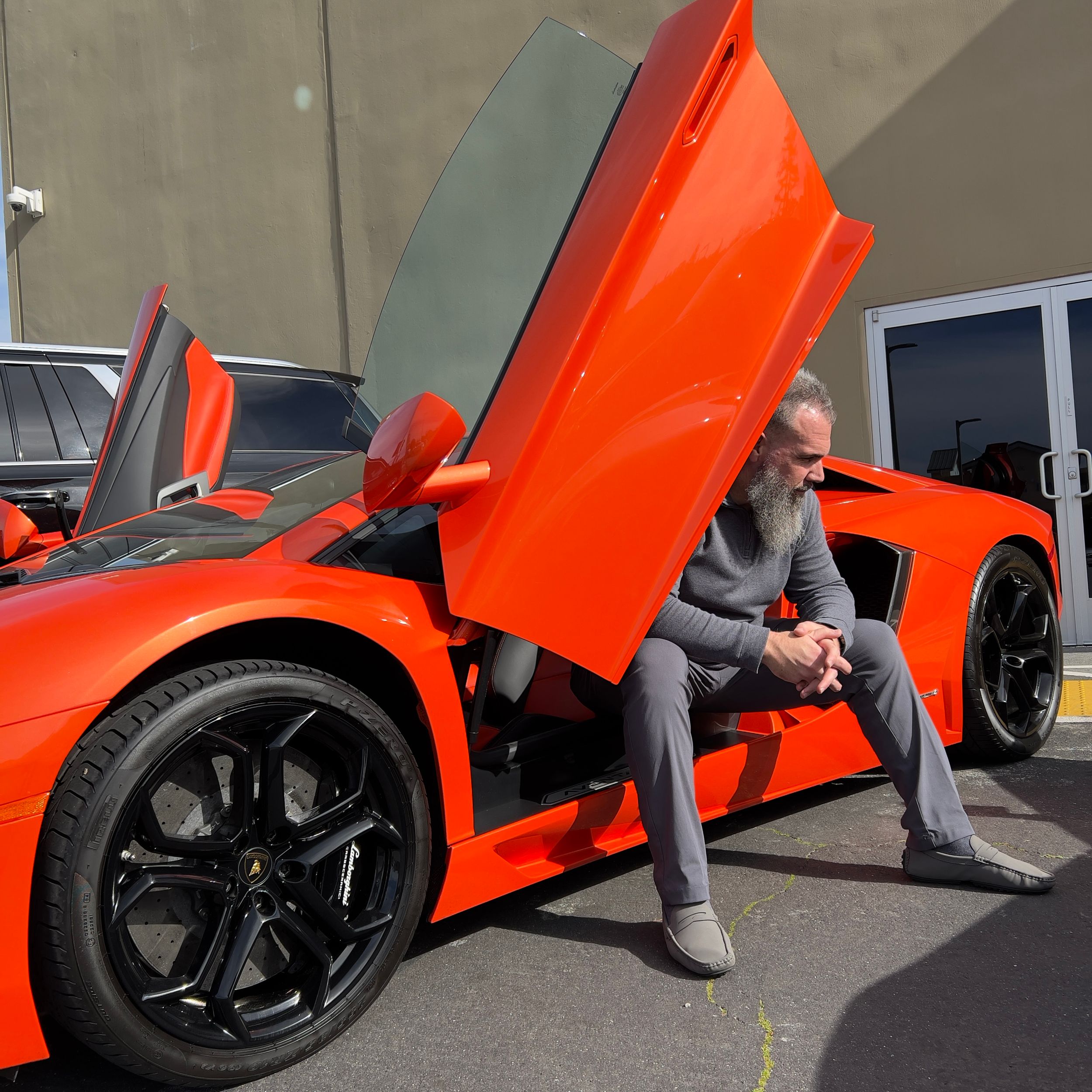 Luxury lifestyle portrait with an orange Lamborghini captured by Raymond C. Hansell Photography.