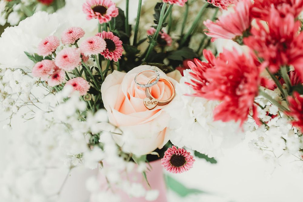 Wedding rings on top of wedding flower bouquet