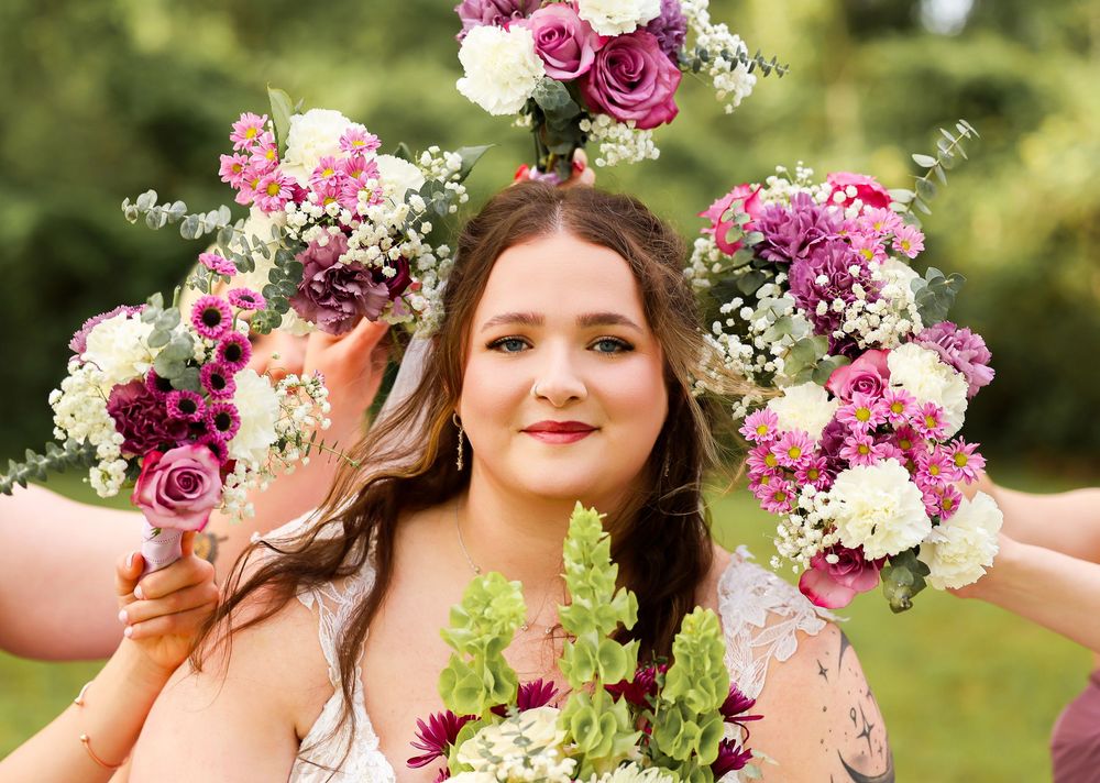 bride surrounded by all her bridal party flower bouquets