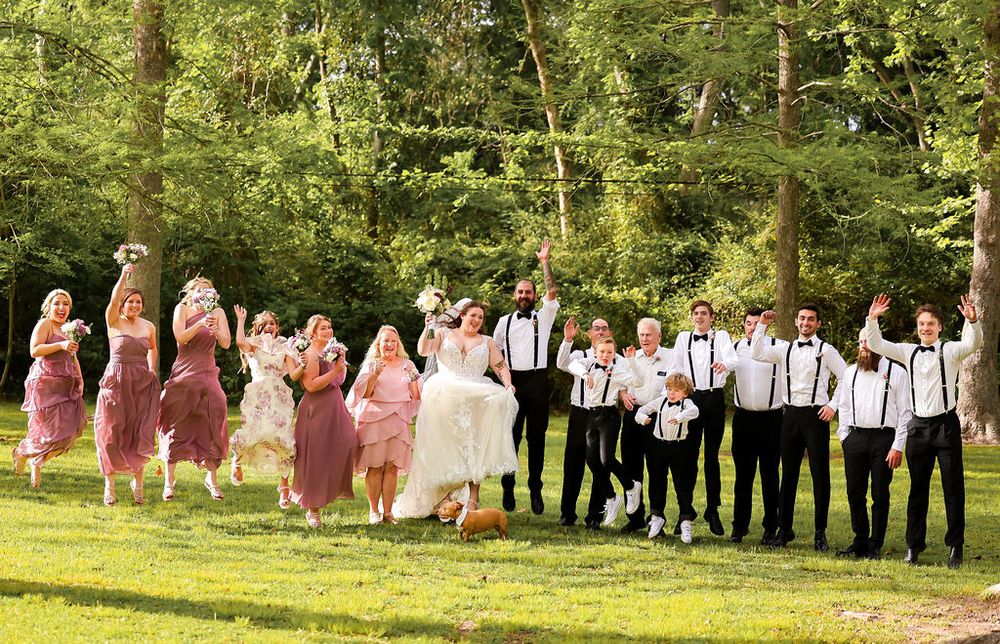 Bridal party all jump in the air for fun for a silly photo