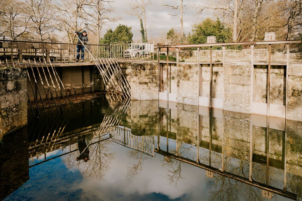 Photographe professionnel Toulouse: Écluse en pierre avec une architecture historique et une eau réfléchissante.