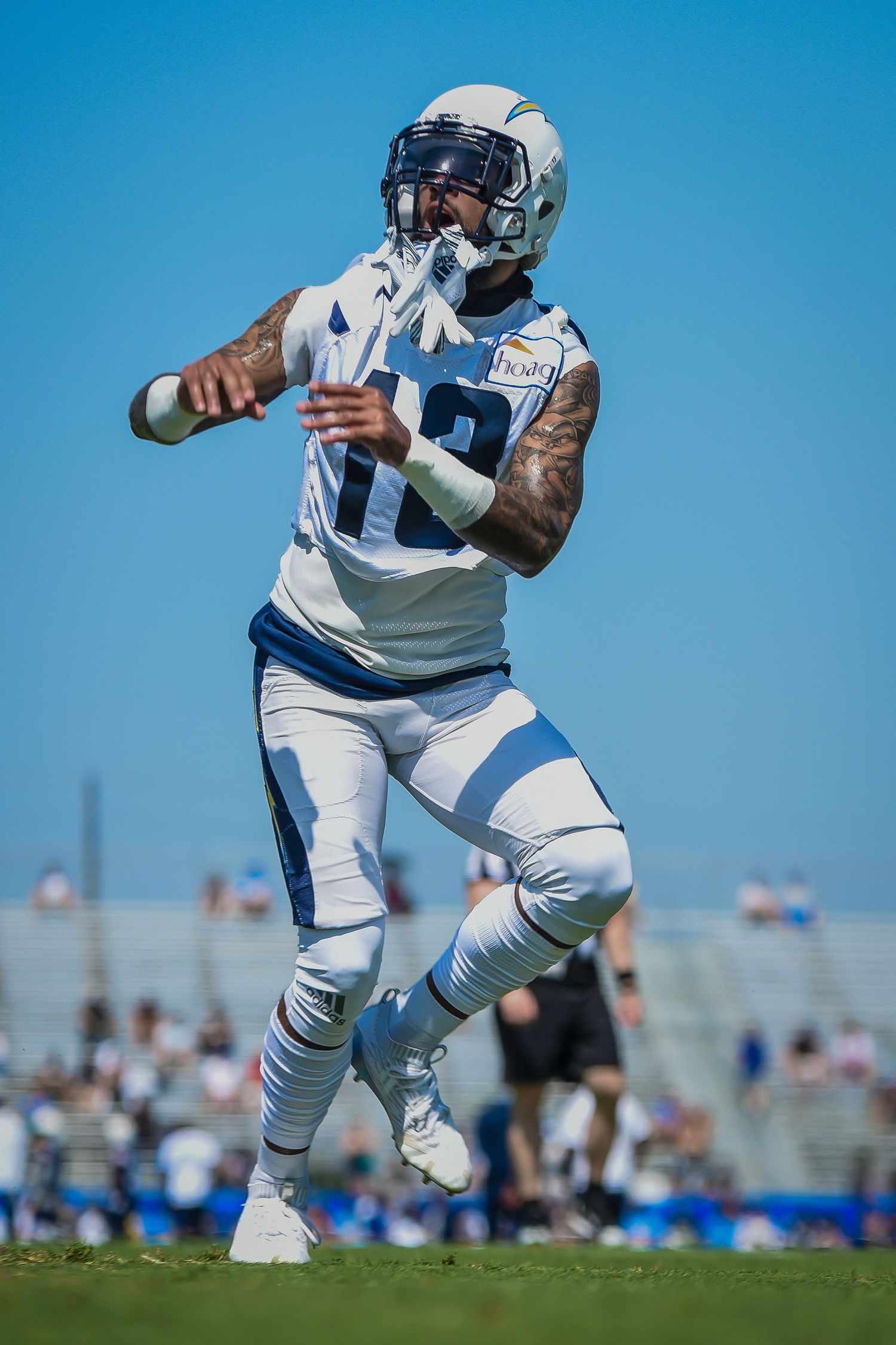 Football player in white Chargers uniform preparing to catch the ball.