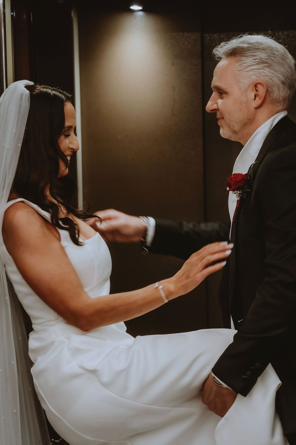 A couple dancing together at their wedding reception, with the bride's white dress flowing gracefully as they move.