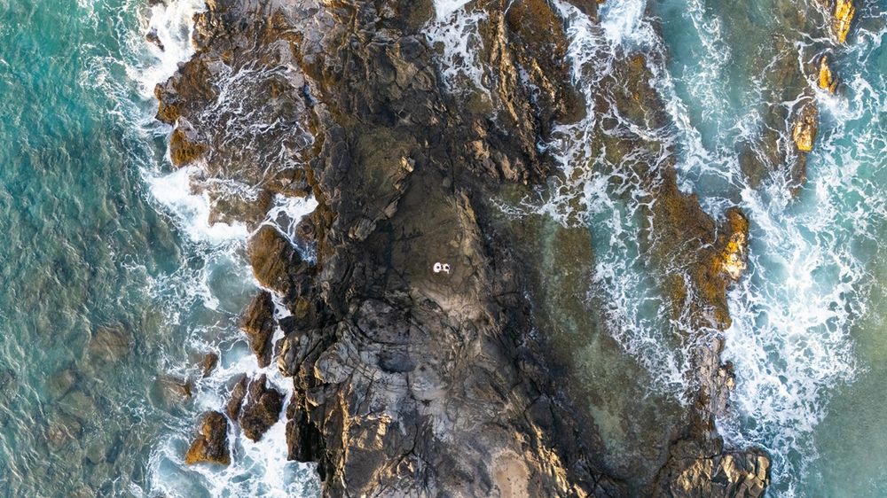 Maui couple engagement photographer photo against beautiful Maui sunset beach cliff by ohwowfotos.
