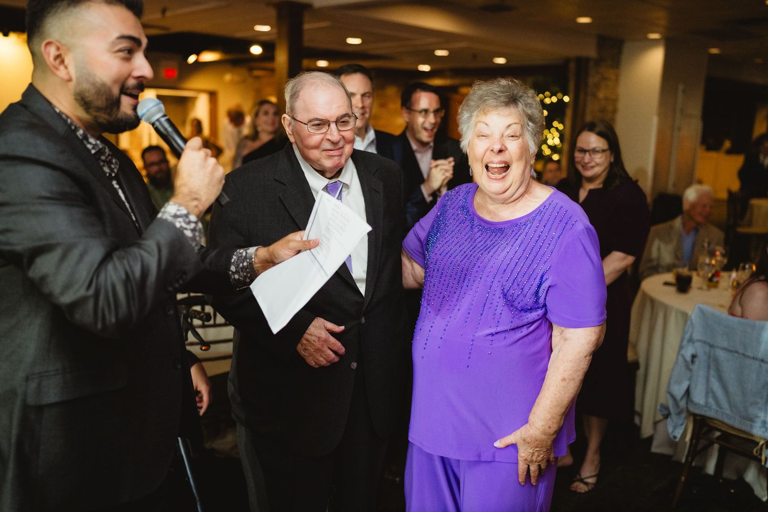 Guests dancing and laughing together during lively wedding reception celebration.