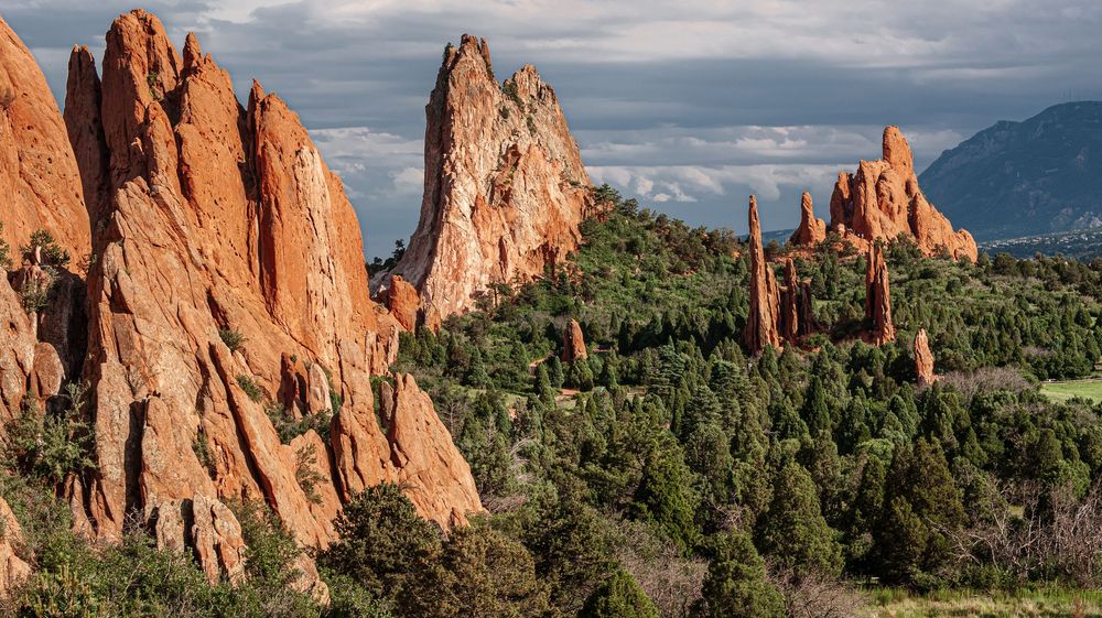 Dramatic red rock formations at Garden of the Gods park under cloudy sky.
