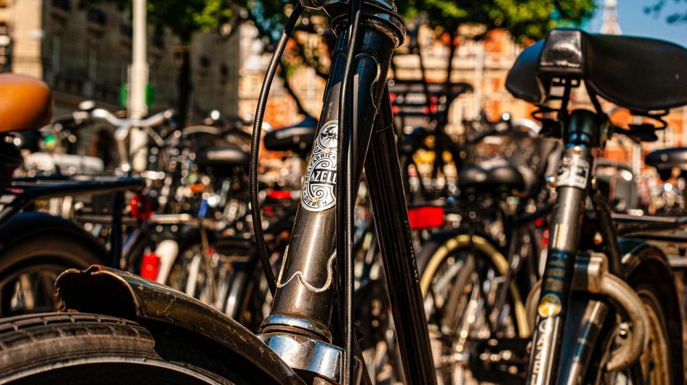 Parked bicycles create pattern of handlebars and wheels in urban setting.